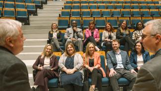 Groupe enthousiaste dans l'auditorium devant deux formateurs assis sur scène