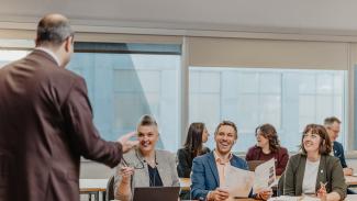 Groupe enthousiaste en classe devant formateur