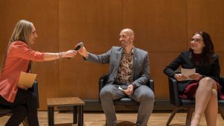 Panel de leaders souriants dont une personne qui passe le micro à une autre