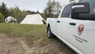 Le camion du Conseil des Innus de Pessamit et les tentes aménagées sur le site de Papinachois.